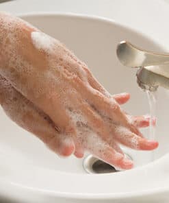 Washing hands with soap and water at a sink.